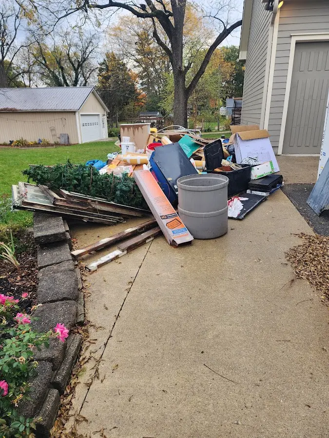 Dumpster being loaded with debris for 12 Yard Dumpster Rental in Lemay